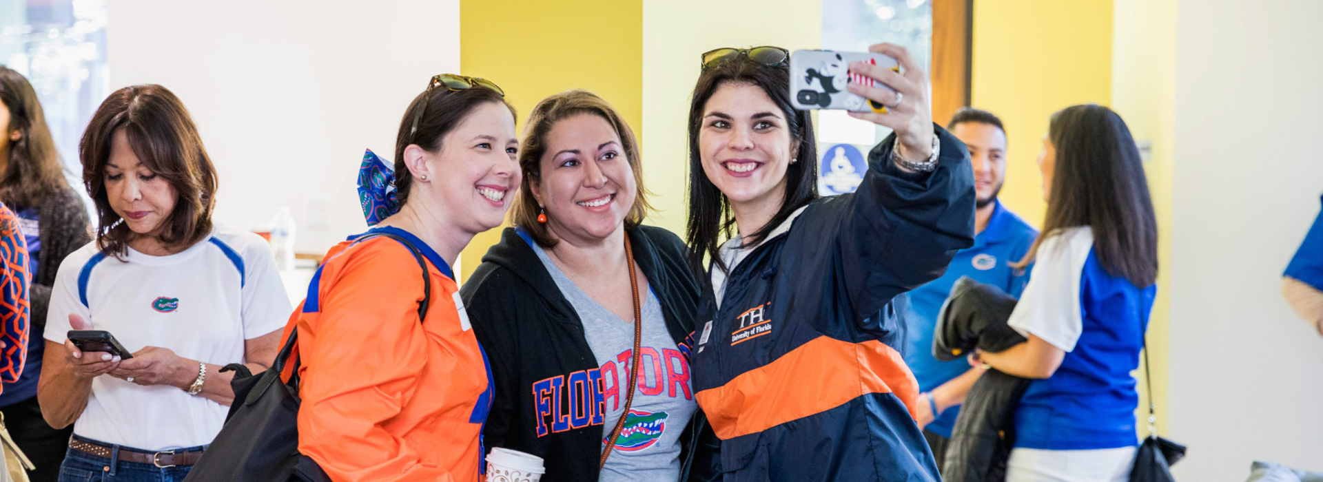 Three women stand together for a selfie style photo.